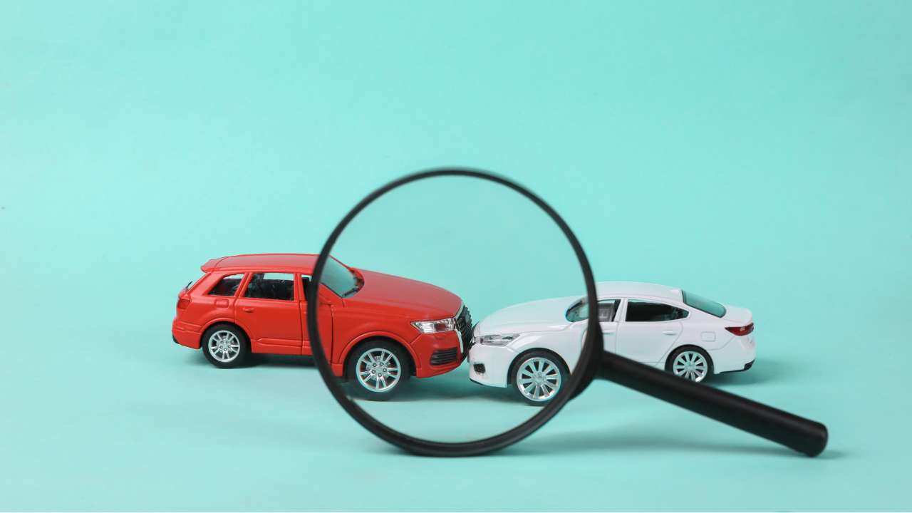 2 auto's met de bumper tegen elkaar aan met een vergrootglas