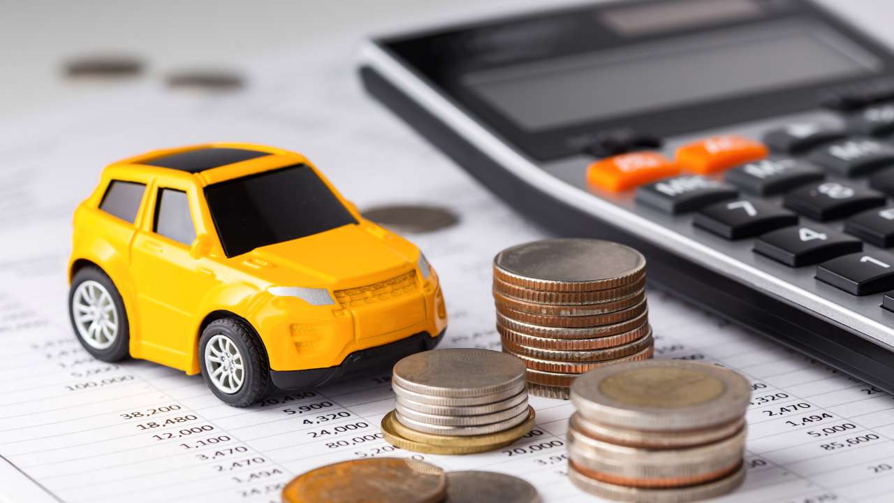 mini auto naast rekenmachine en euromunten