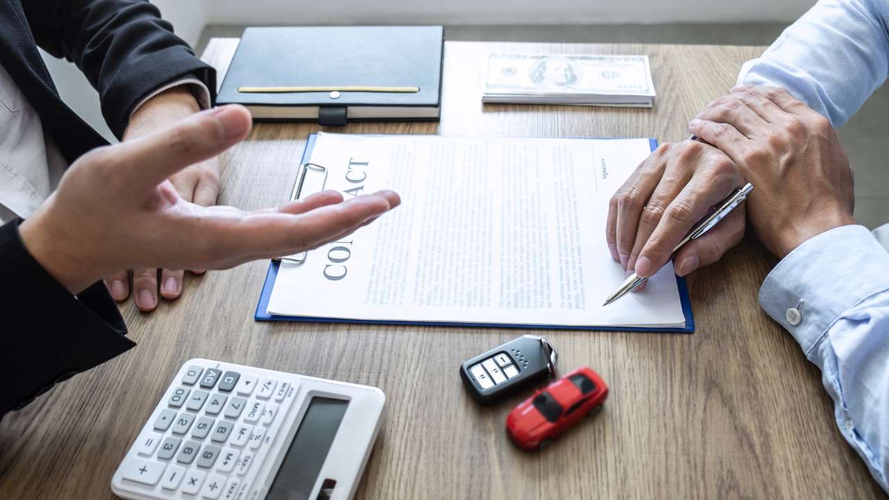 autosleutel contract en 2 personen aan tafel