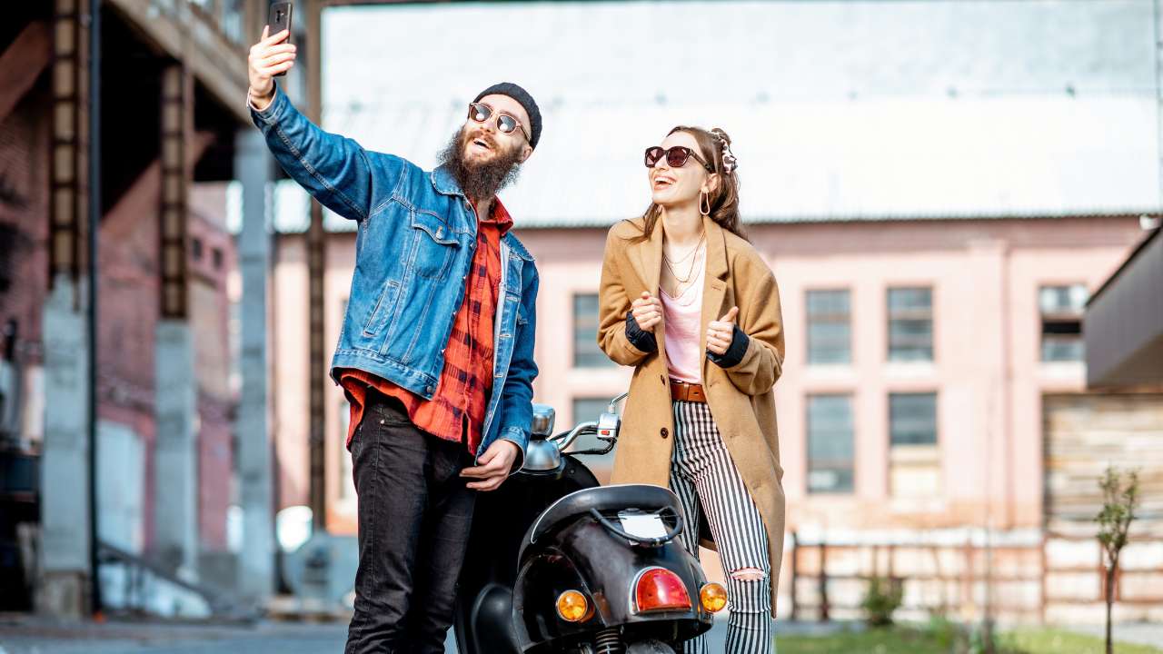 2 mensen die een scooter delen